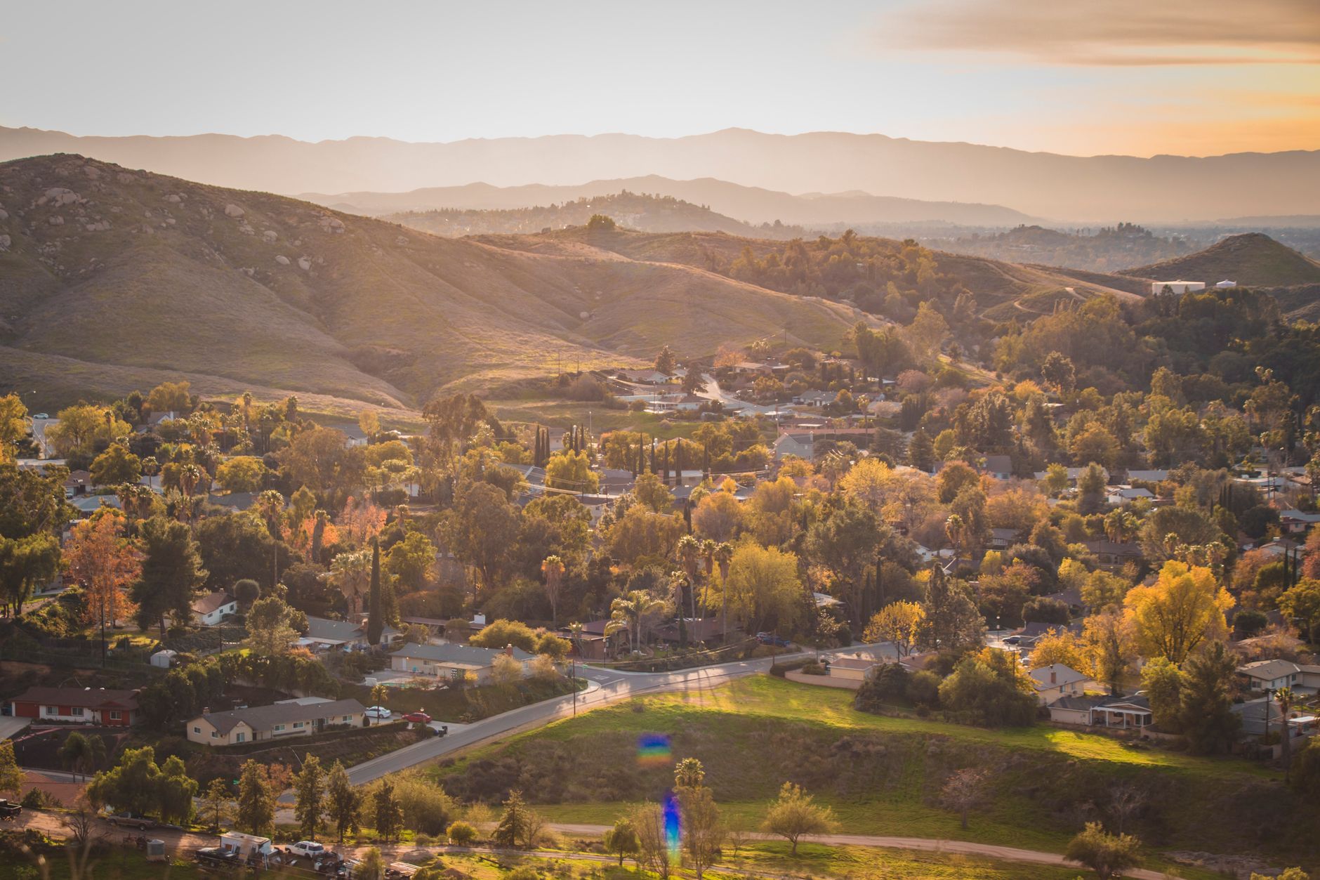 Sunset over the low hills of Yorba Linda, the residential setting around Las Palomas Park's lit tennis courts