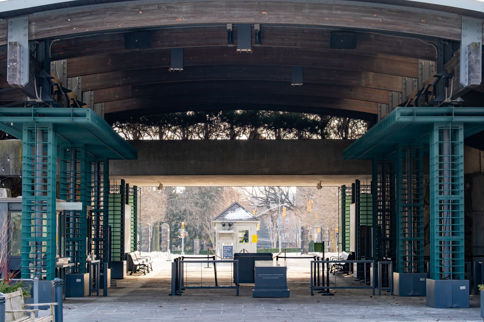 Green parkland in the Bronx under early-evening light, the park setting around Crotona Park Tennis Center's lit courts