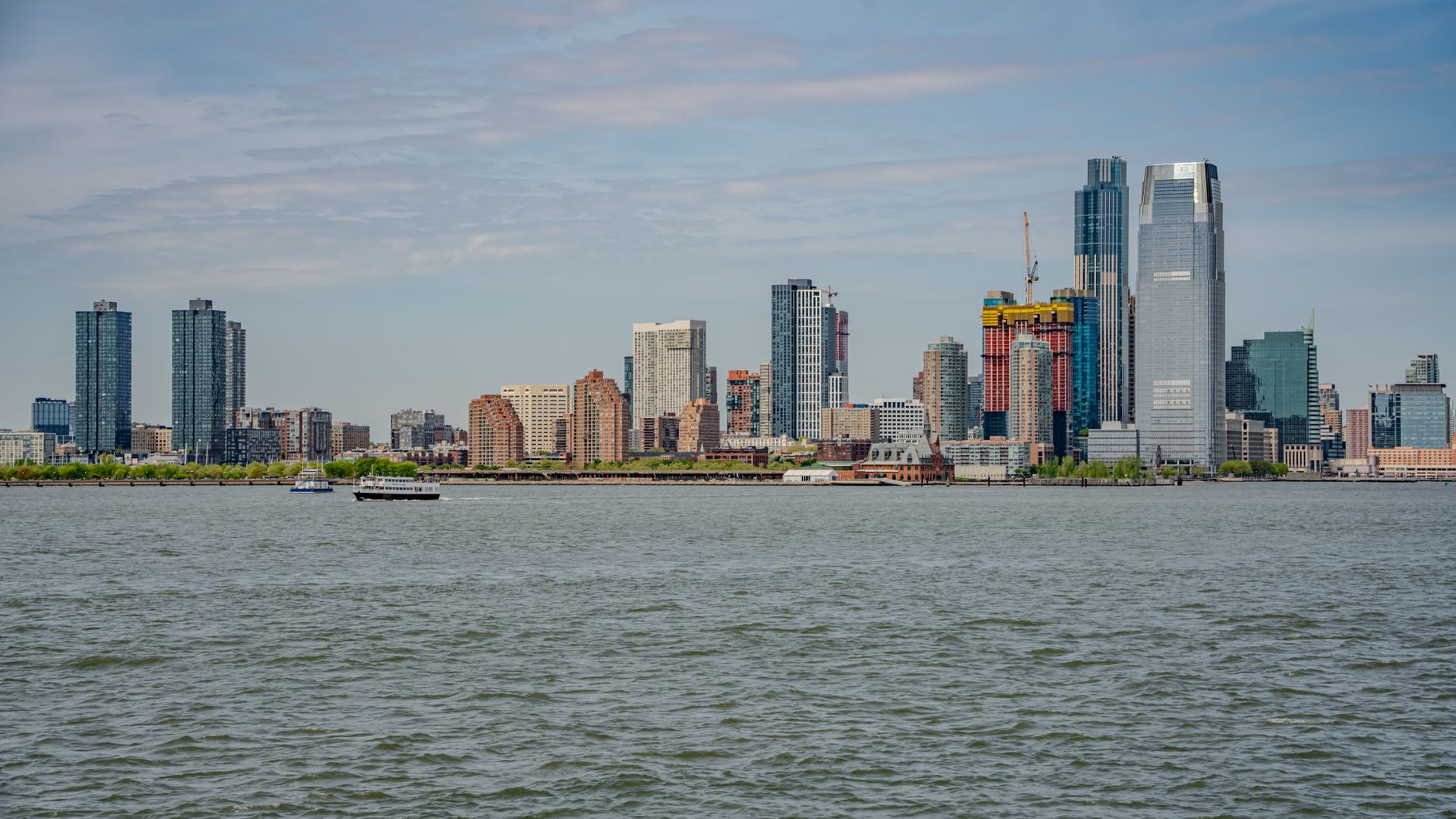 The Jersey City skyline at dusk, the urban-park setting around Pershing Field's tennis courts