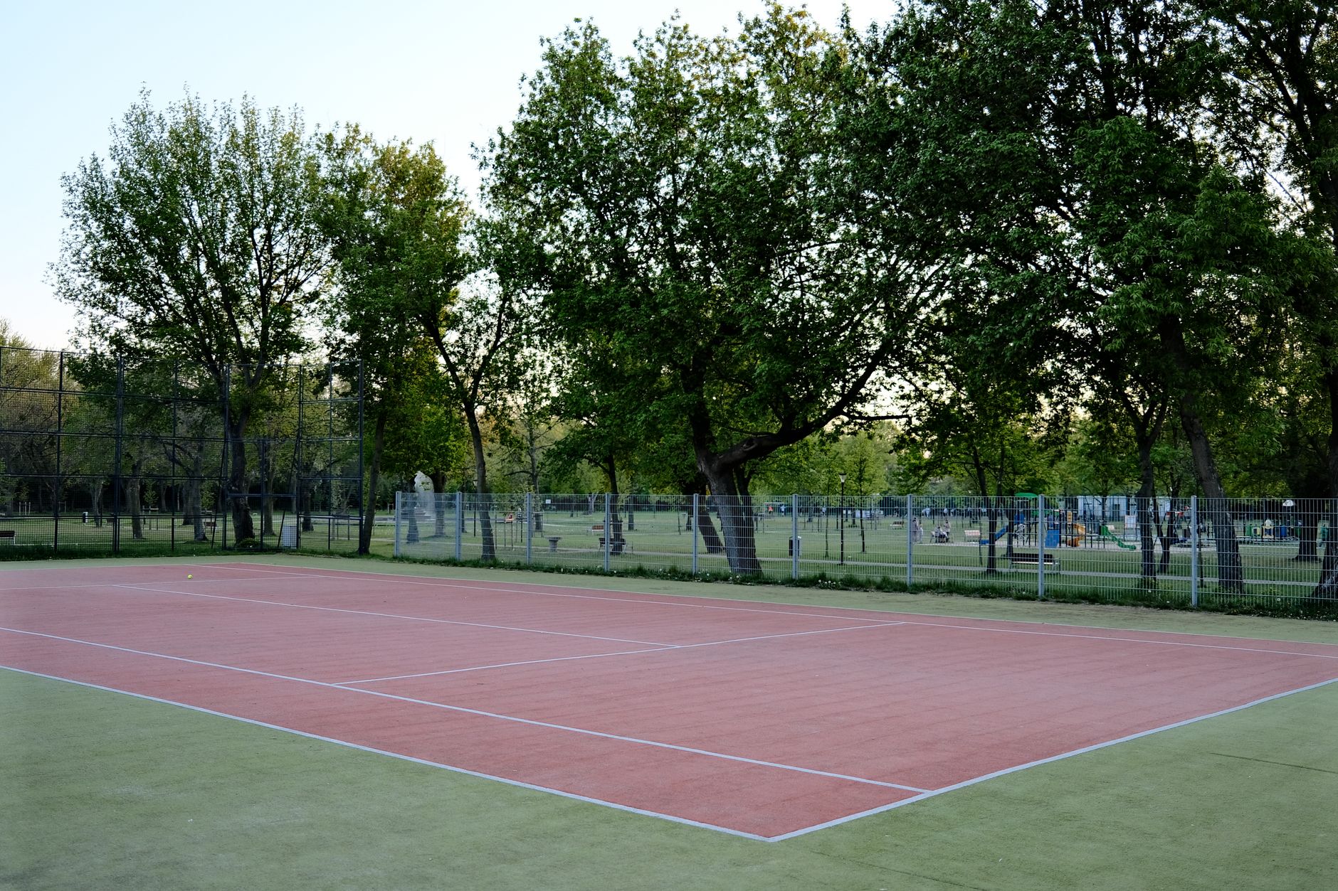 A leafy Ottawa neighbourhood park, representative of the public courts where A Love of Tennis runs its free group lessons