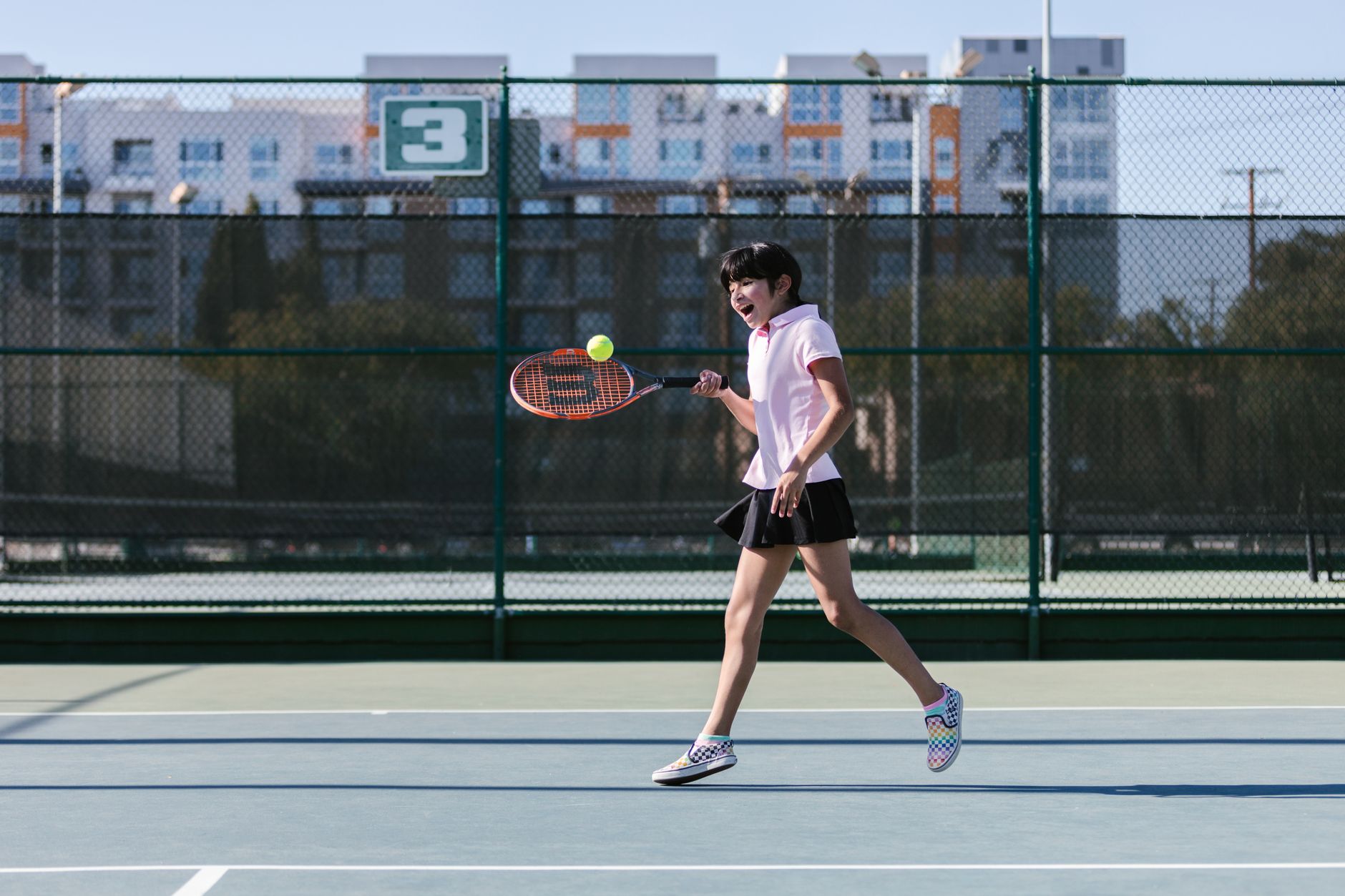 A modern outdoor tennis stadium court with blue hard surface, representative of the Carson tennis complex